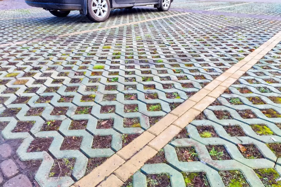 Close-up of green permeable street with concrete lattice over soil and grass.